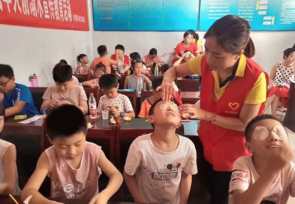 易視界志愿者為孩子貼易視界護眼優品